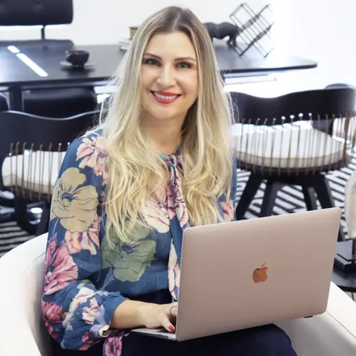 Dra. Jéssica sorrindo, trabalhando no notebook